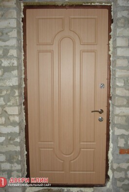Входная дверь цвета миланский орех в кирпичном доме